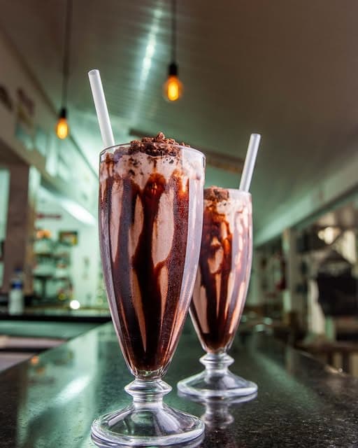 Dois milkshakes de chocolate com calda no balcão do Columbia